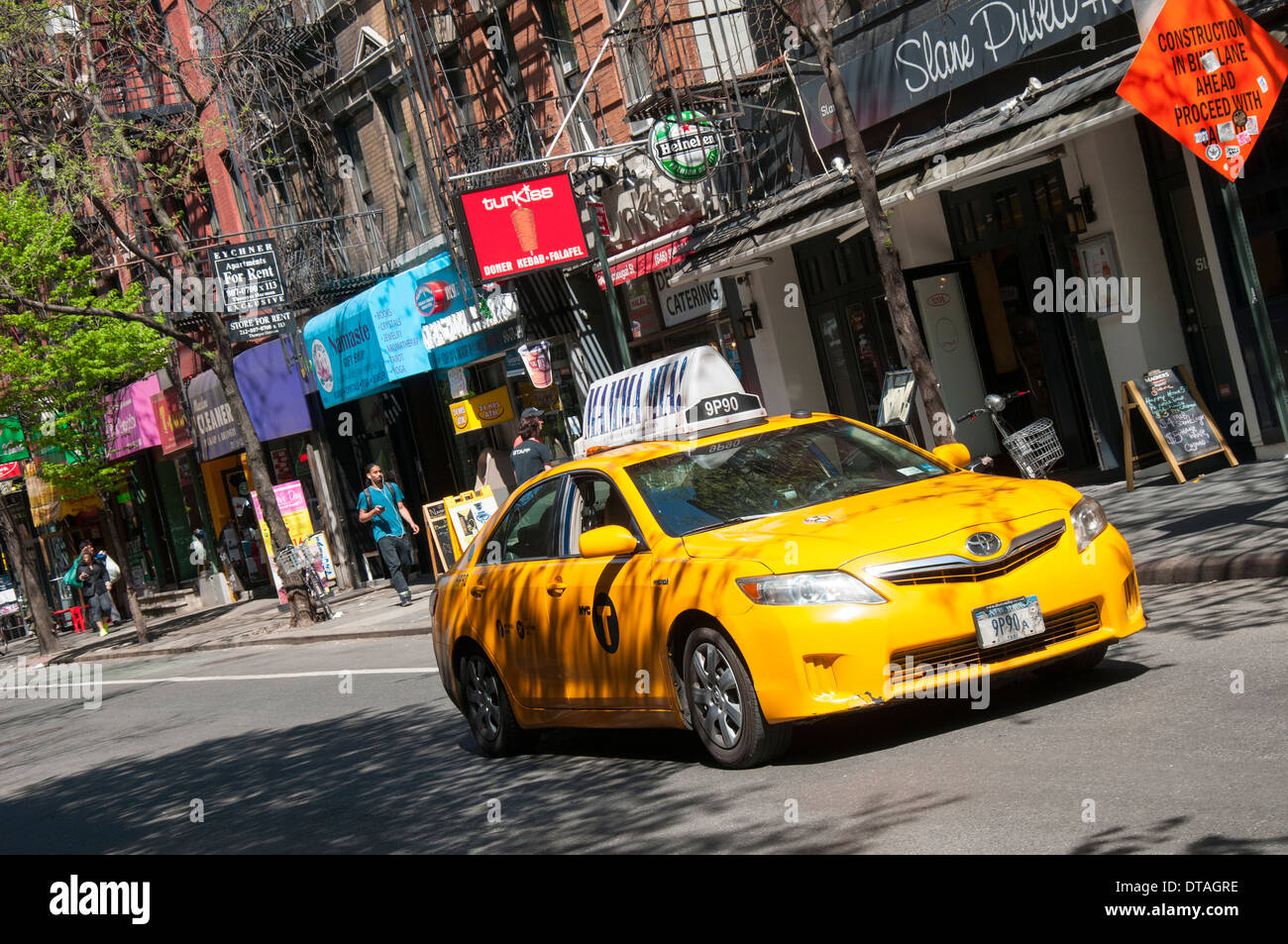 A yellow cab driving through Greenwich Village in Manhattan New York City, USA Stock Photo