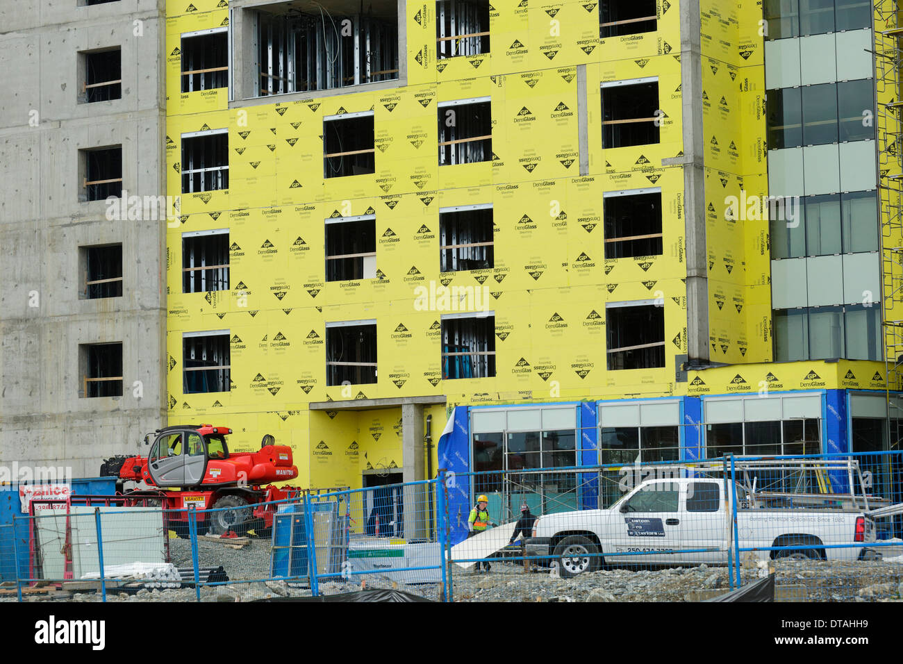 Workmen carrying drywall at building construction site-Victoria, British Columbia, Canada. Stock Photo