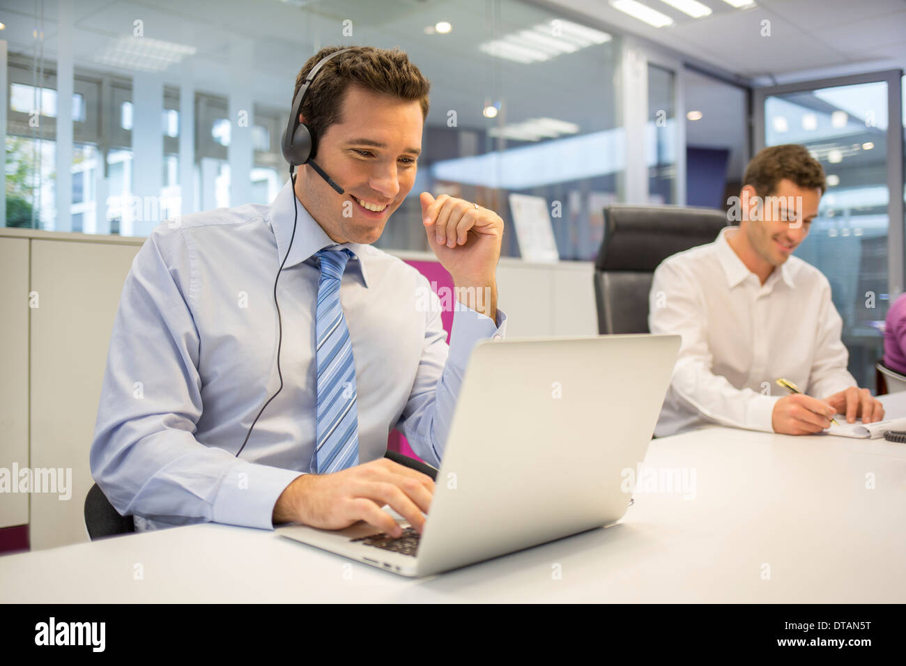 Businessman in office on phone with headset, call conference Stock Photo