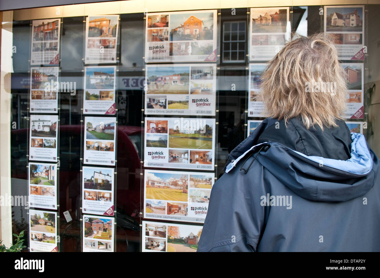 Woman looking at Estate Agent window, Leatherhead, Surrey, England, UK