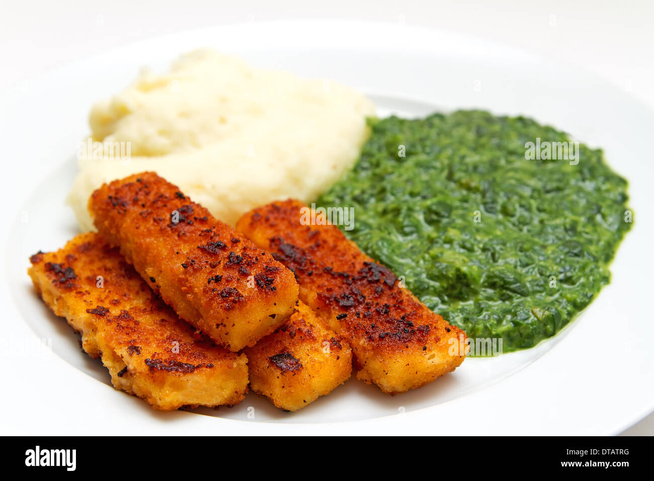 fried fish fillet with mashed potatoes and spinach Stock Photo