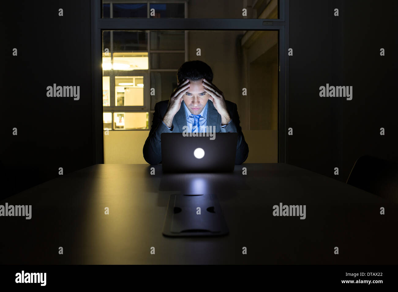 Businessman working late in his office on laptop Stock Photo