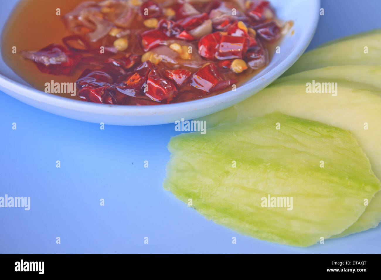 mangoes with sauce, mangoes dipped into a sweet fishy paste with dried shrimp and red onions in plate Stock Photo