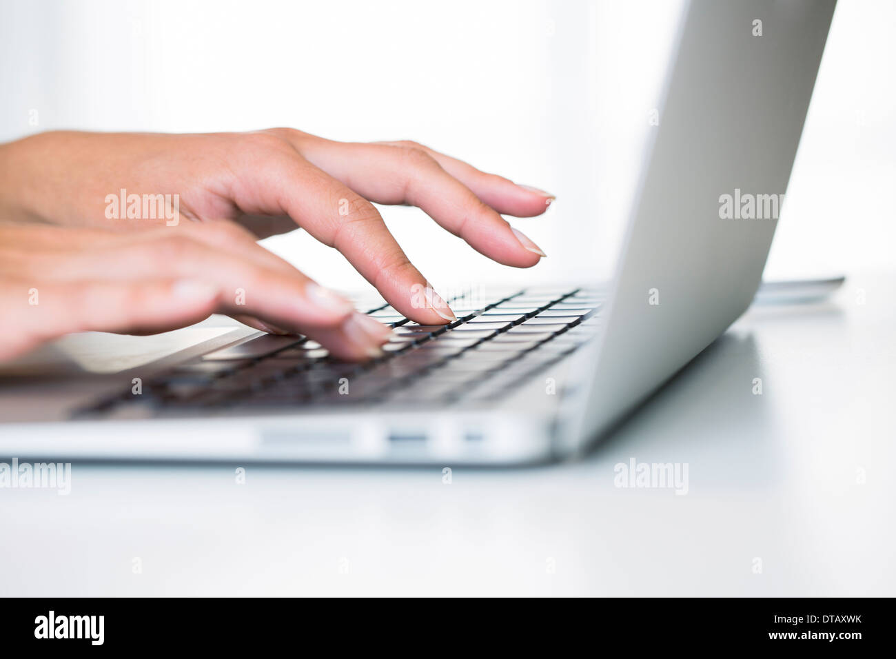 Close-up on woman hands typing on keyboard laptop computer, office, desk Stock Photo