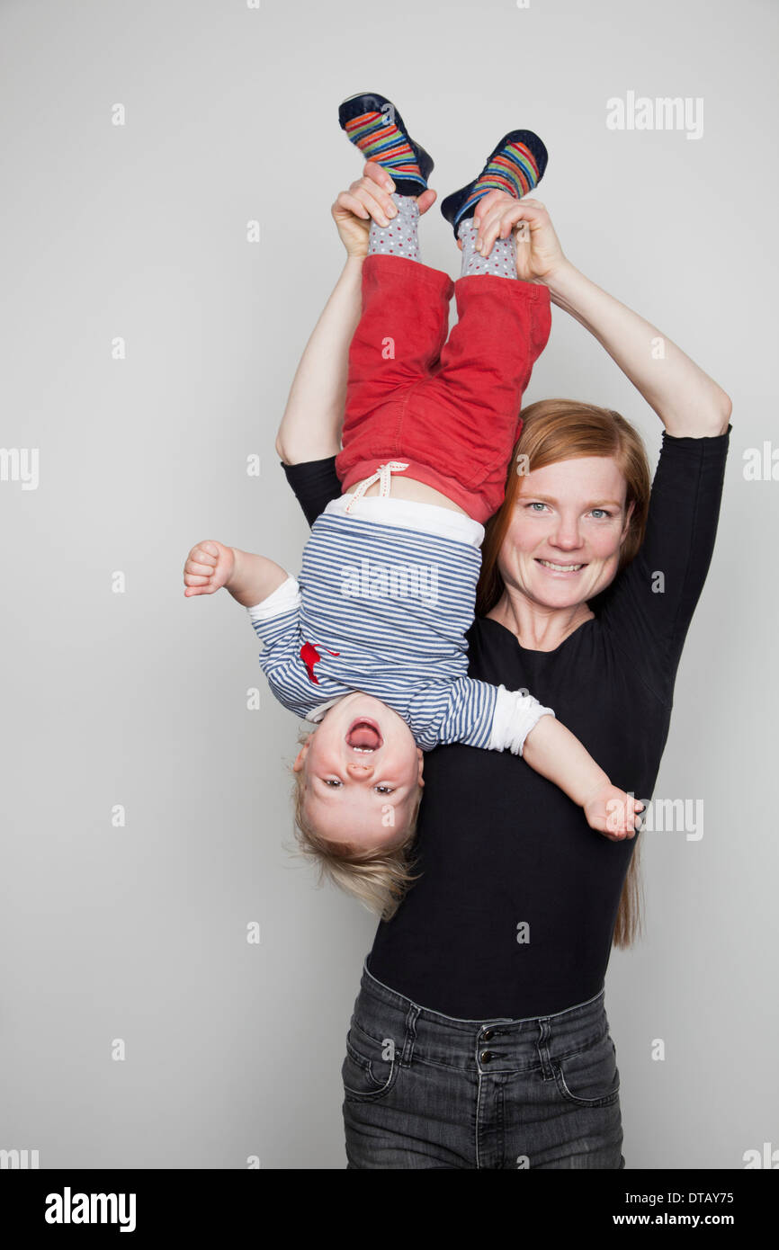 Mother holding baby boy upside down Stock Photo Alamy