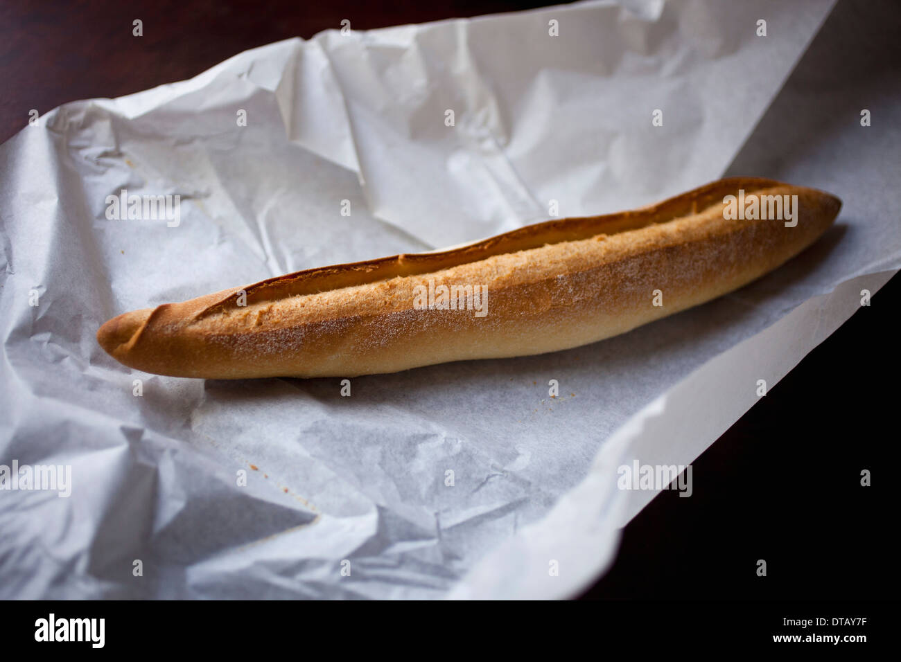 Baguette on paper, close-up Stock Photo