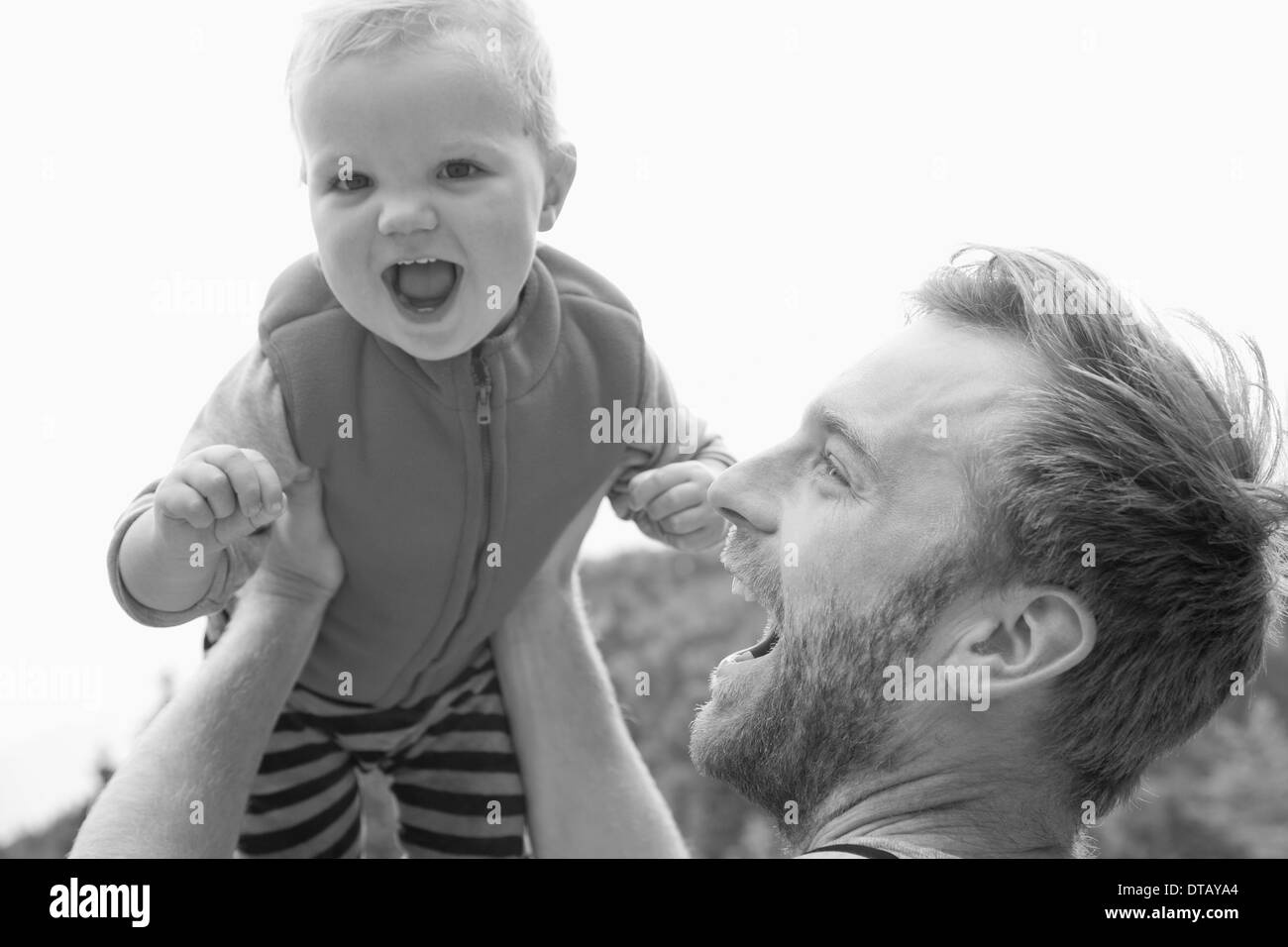 Father lifting his son up in the air playfully Stock Photo