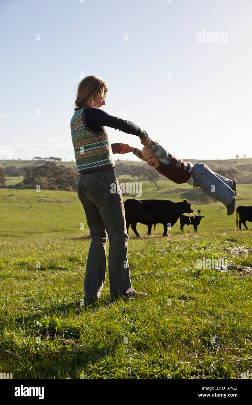 Mother swinging her baby boy Stock Photo