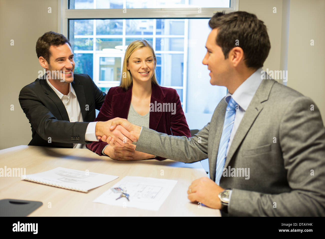 Couple meeting with financial adviser, handshake Stock Photo
