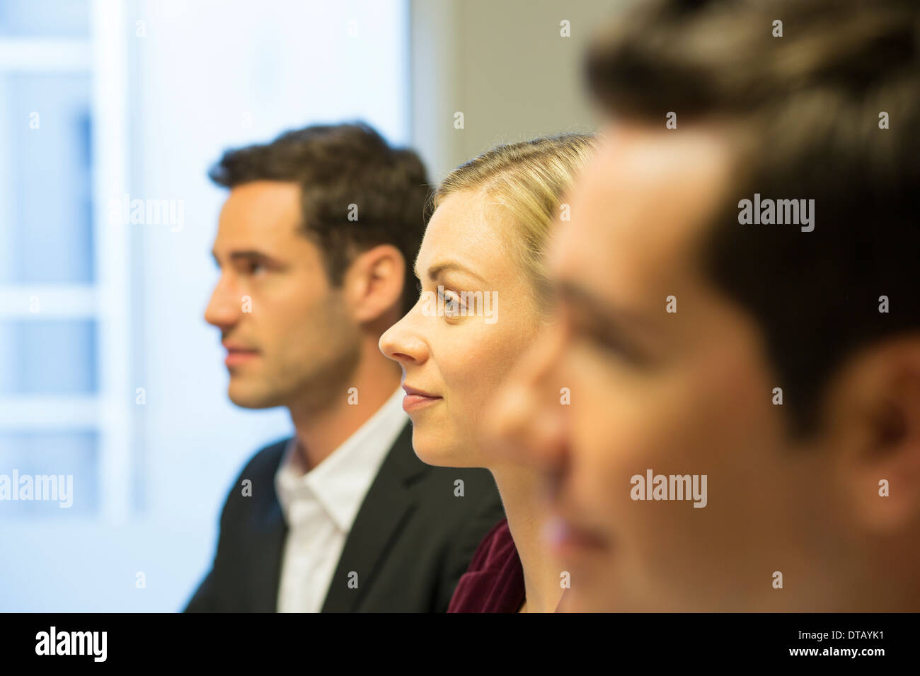 Three colleagues sitting at a business meeting, focus on pretty woman Stock Photo