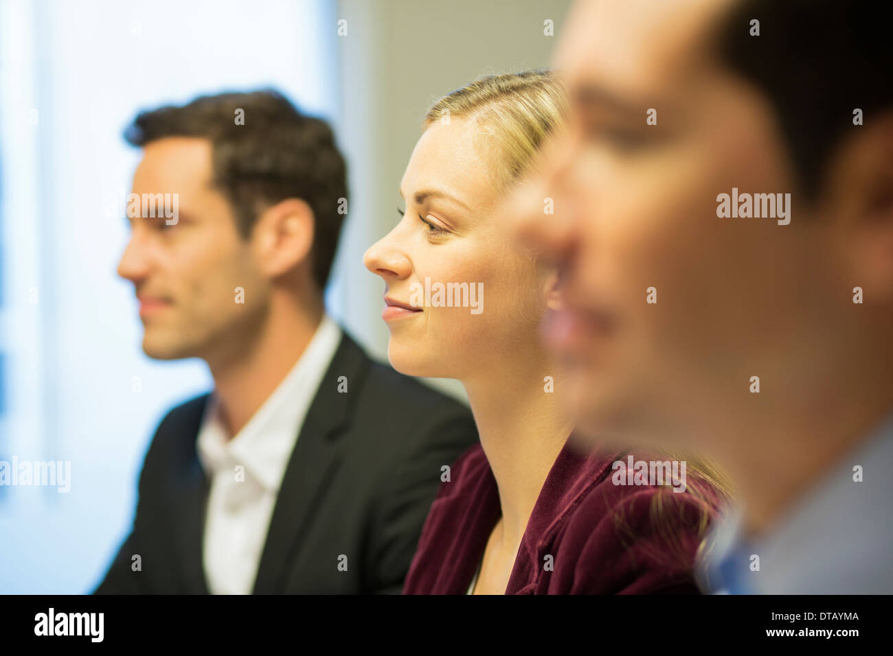 Three colleagues sitting at a business meeting, focus on pretty woman Stock Photo