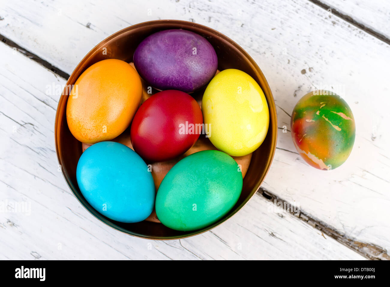 Brightly colored Easter eggs in a beautiful copper bowl Stock Photo