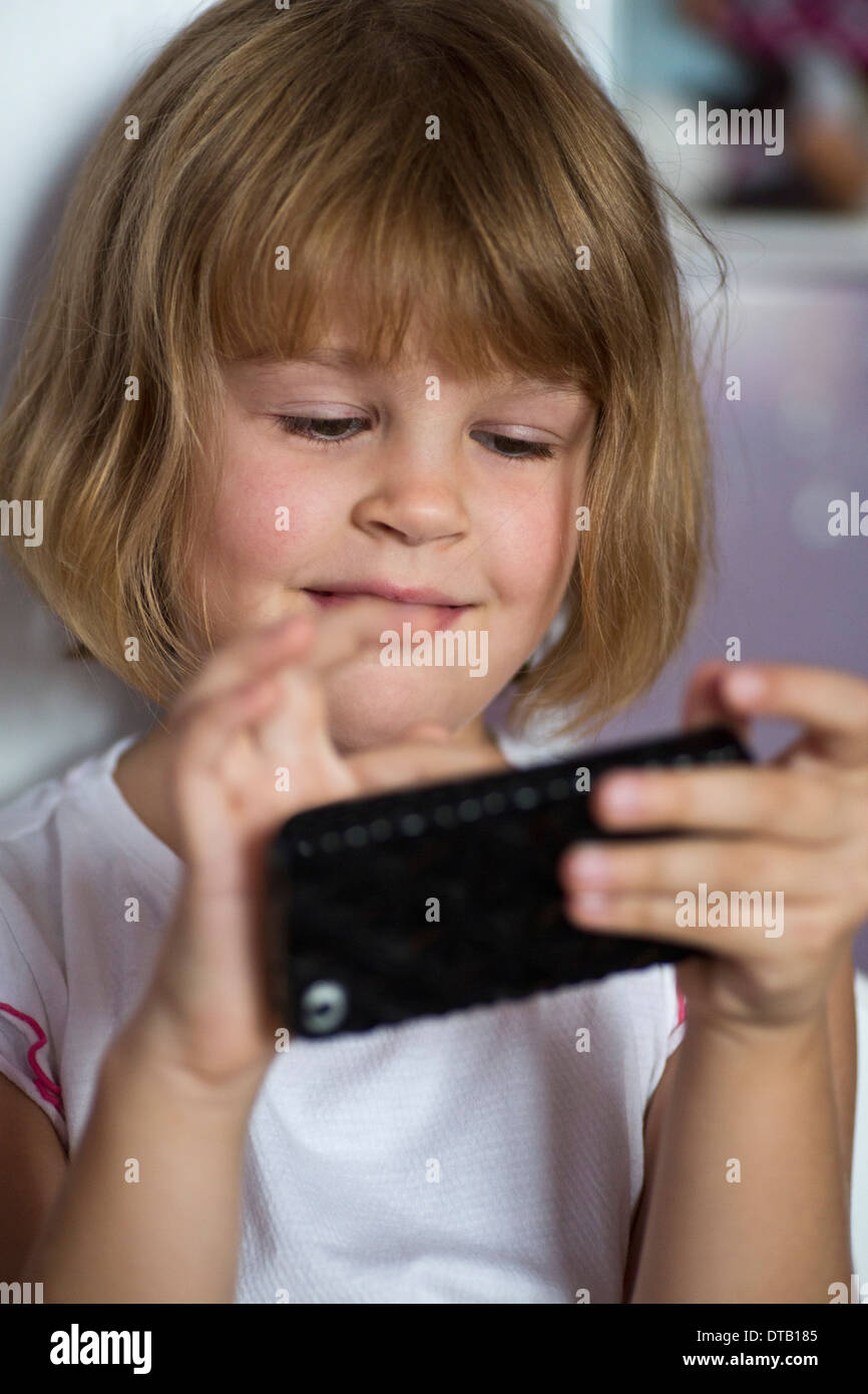 Girl playing on mobile phone, close-up Stock Photo