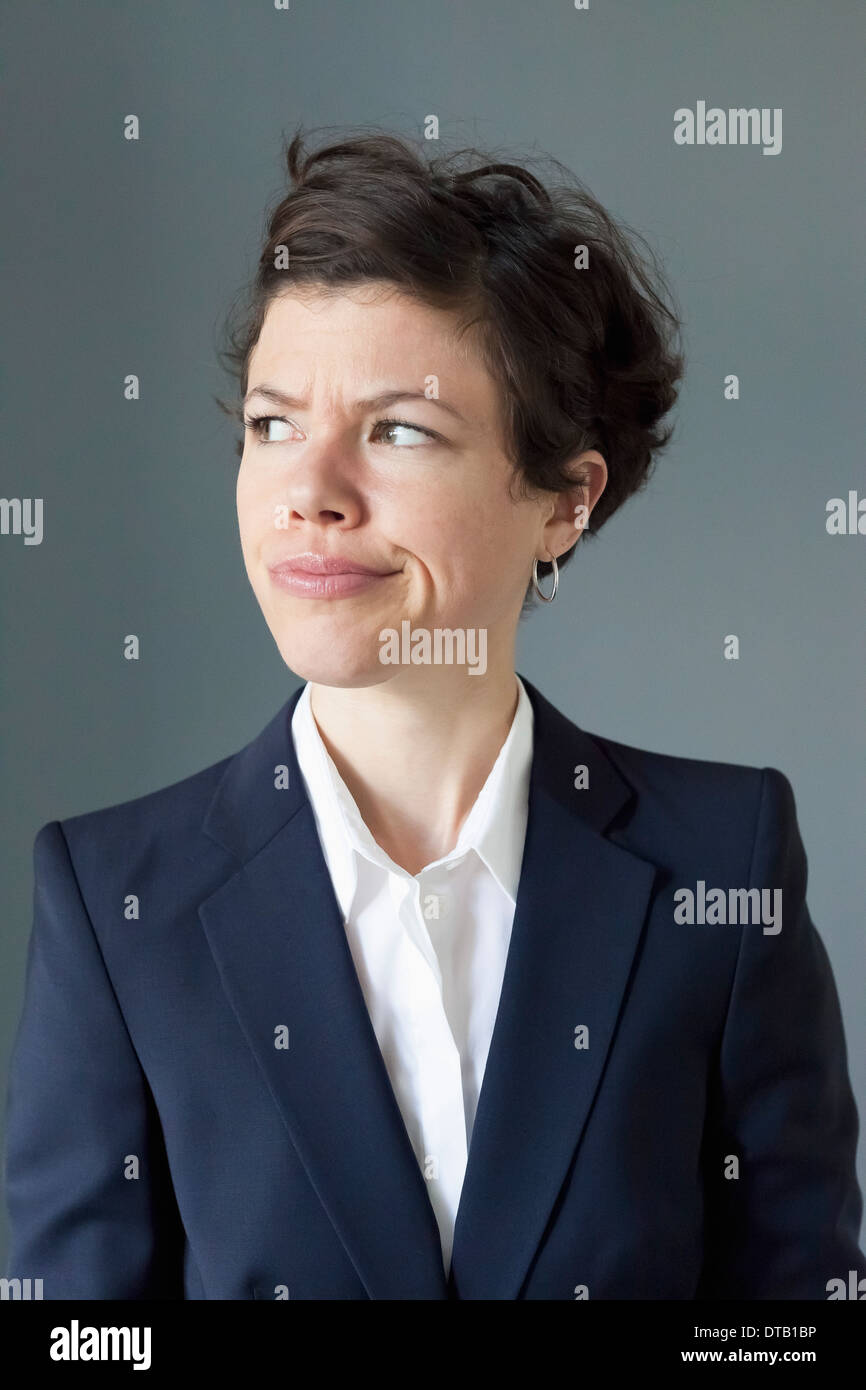 Mid adult woman frowning while looking away, close-up Stock Photo