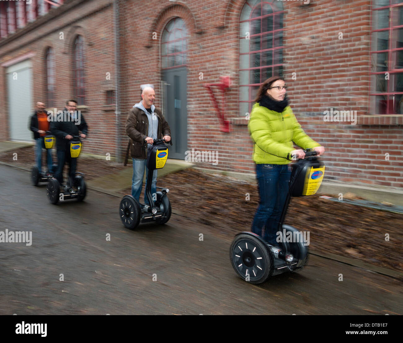 Four persons drive their segways. Stock Photo