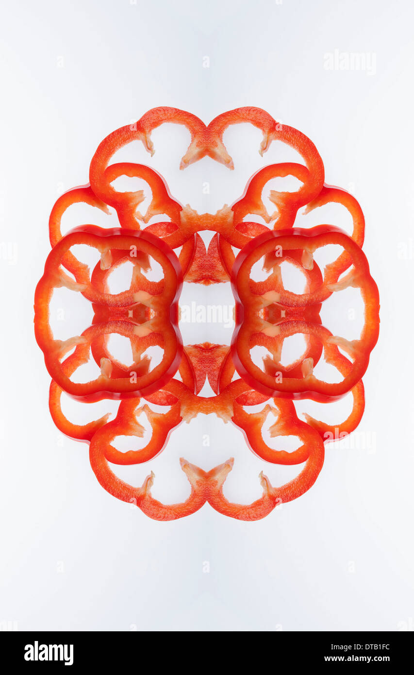 A digital composite of mirrored images of slices of red bell pepper Stock Photo