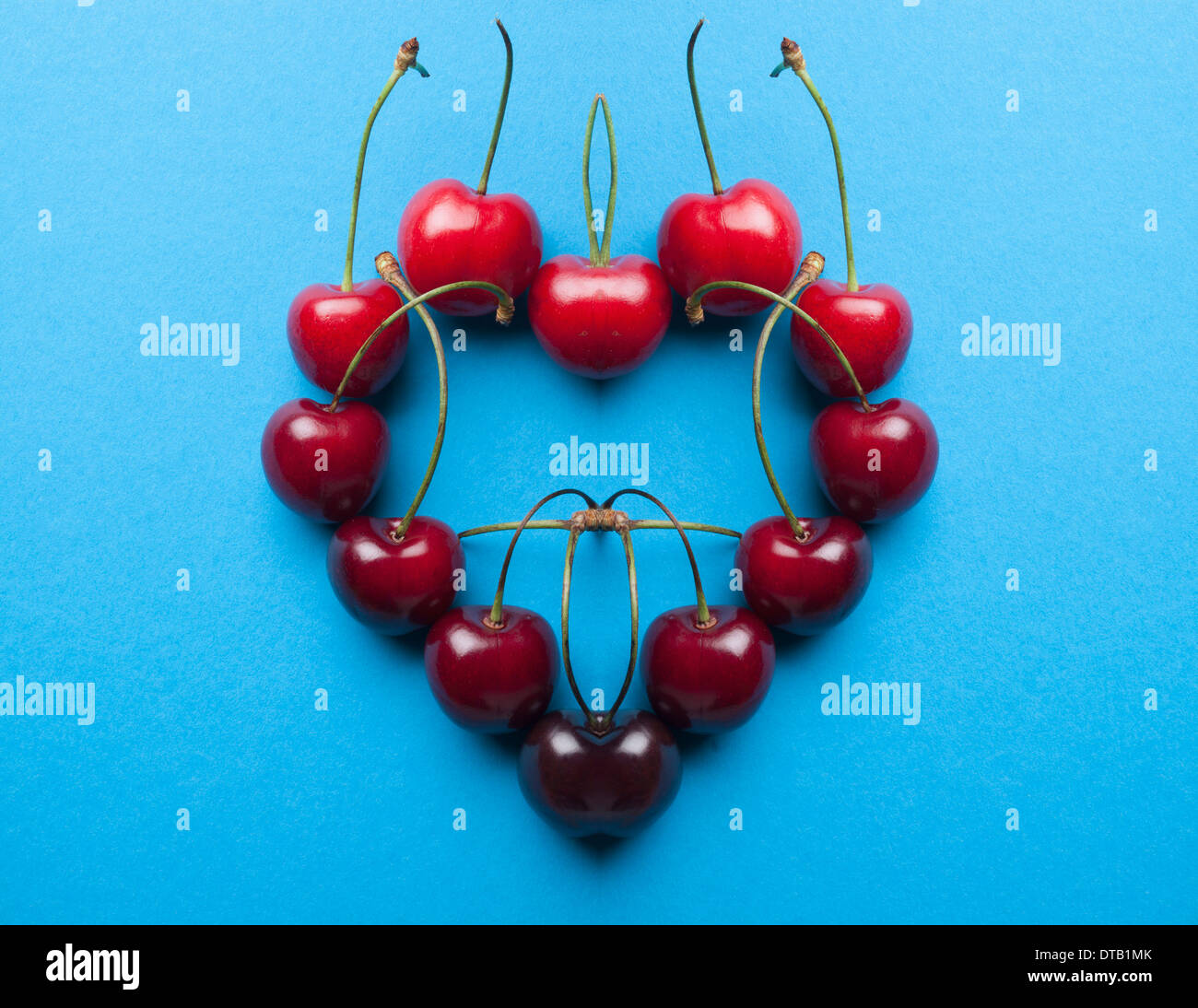 A digital composite of mirrored images of an arrangement of cherries in a heart shape Stock Photo