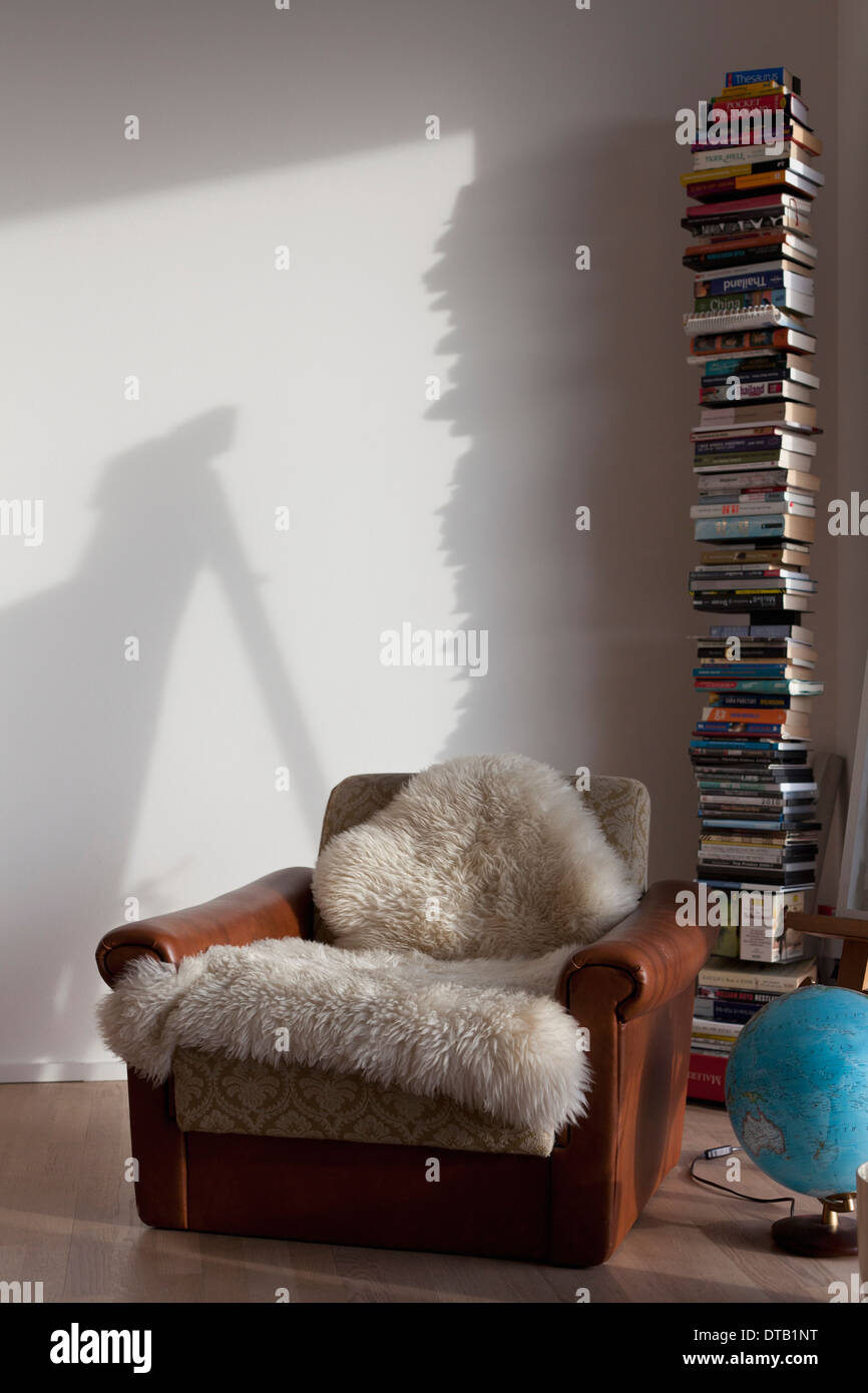 Stack of books and armchair in study Stock Photo