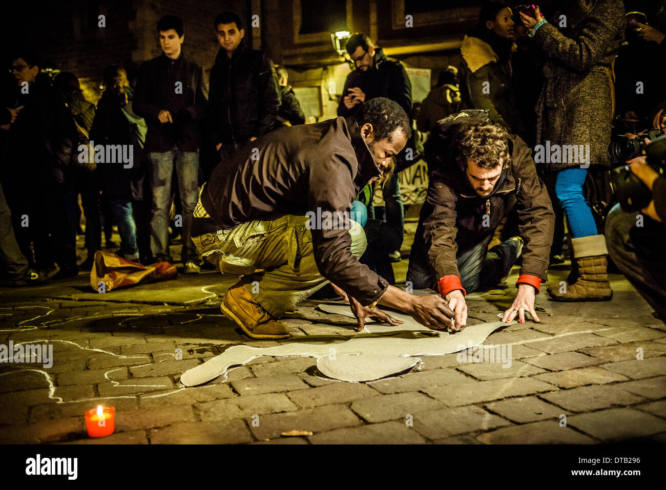 Barcelona, Spain. February 12th, 2014: Immigrant activists paint symbolic chalk outlines of dead bodies for the recent victims of undocumented immigrants at the Spanish border of Ceuta. Stock Photo