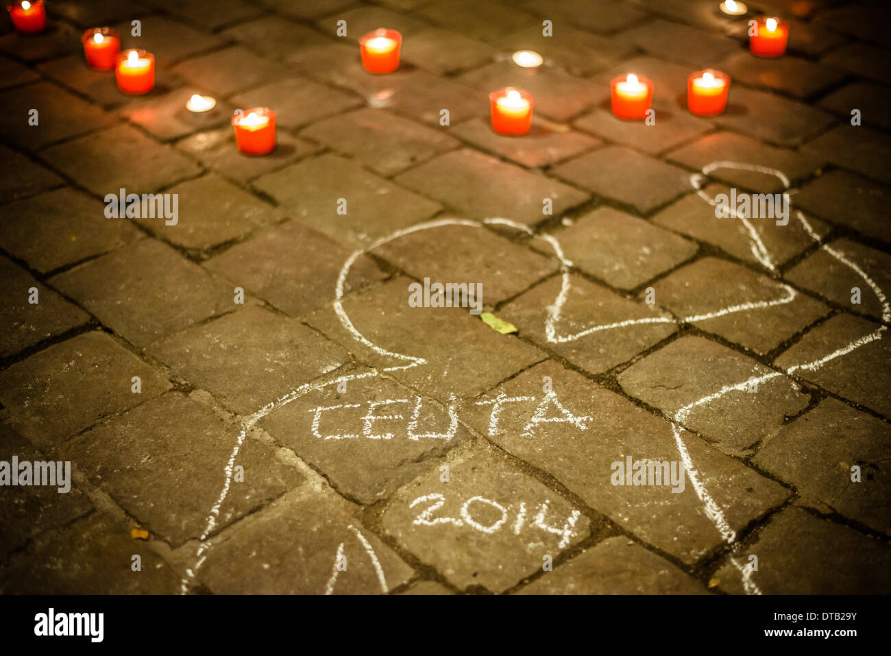 Barcelona, Spain. February 12th, 2014: Painted chalk outlines of dead bodies and candles decorate the floor during a commemoration for the recent victims of undocumented immigrants at the Spanish border of Ceuta. Stock Photo