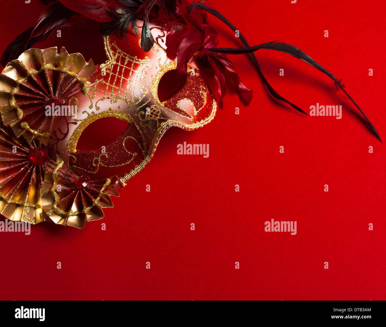 A red and gold venetian, mardi gras mask on a red background Stock Photo