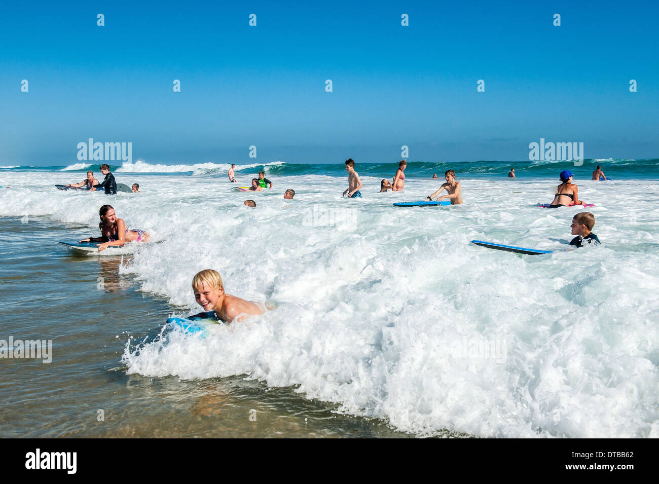 Children enjoy body boarding the waves at Sedgefield, Eastern Cape, South Africa Stock Photo