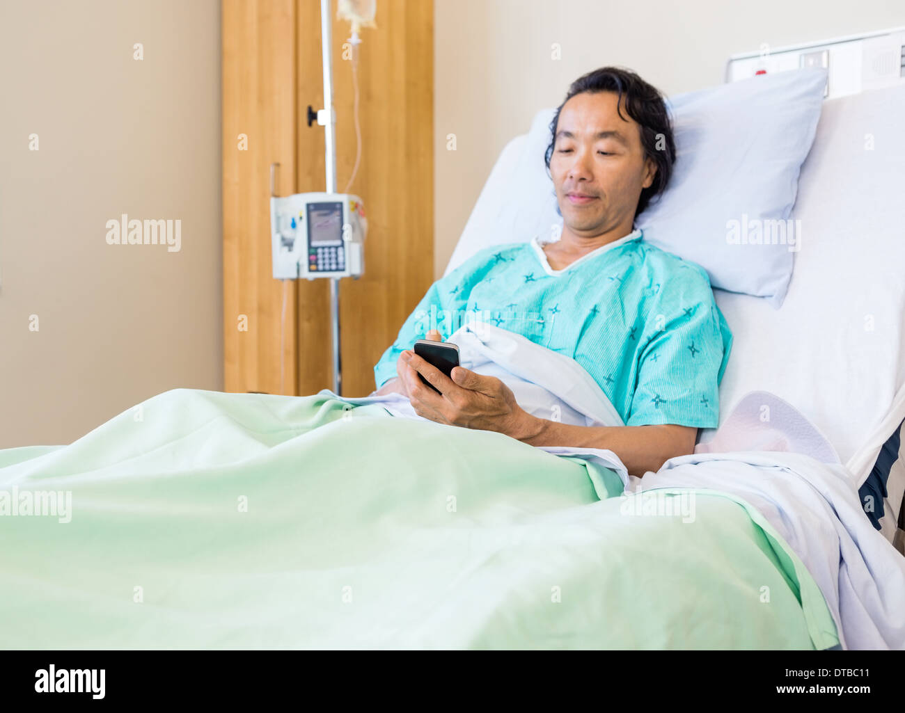 Patient Using Mobile Phone On Hospital Bed Stock Photo Alamy