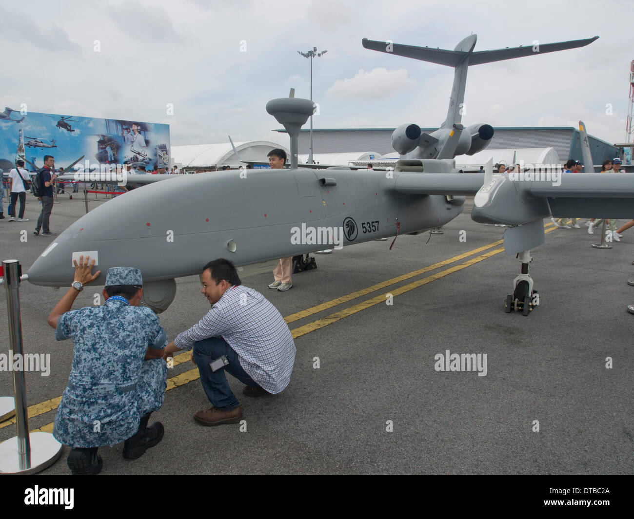 Air Force pilot shows model of drone to visitor at Singapore Air Show