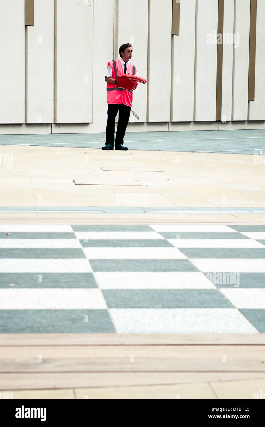 Steward Is Standing To Help Visitors To Go To The Olympic London 2012 Olympic Park, in Westfield shopping Center, Stratford Stock Photo