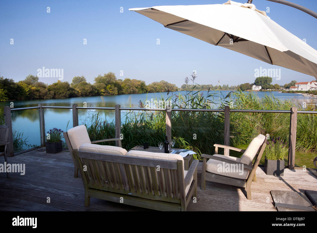 Decking seating area by a lake in The Cotswold Water Park, Gloucestershire, England, UK Stock Photo