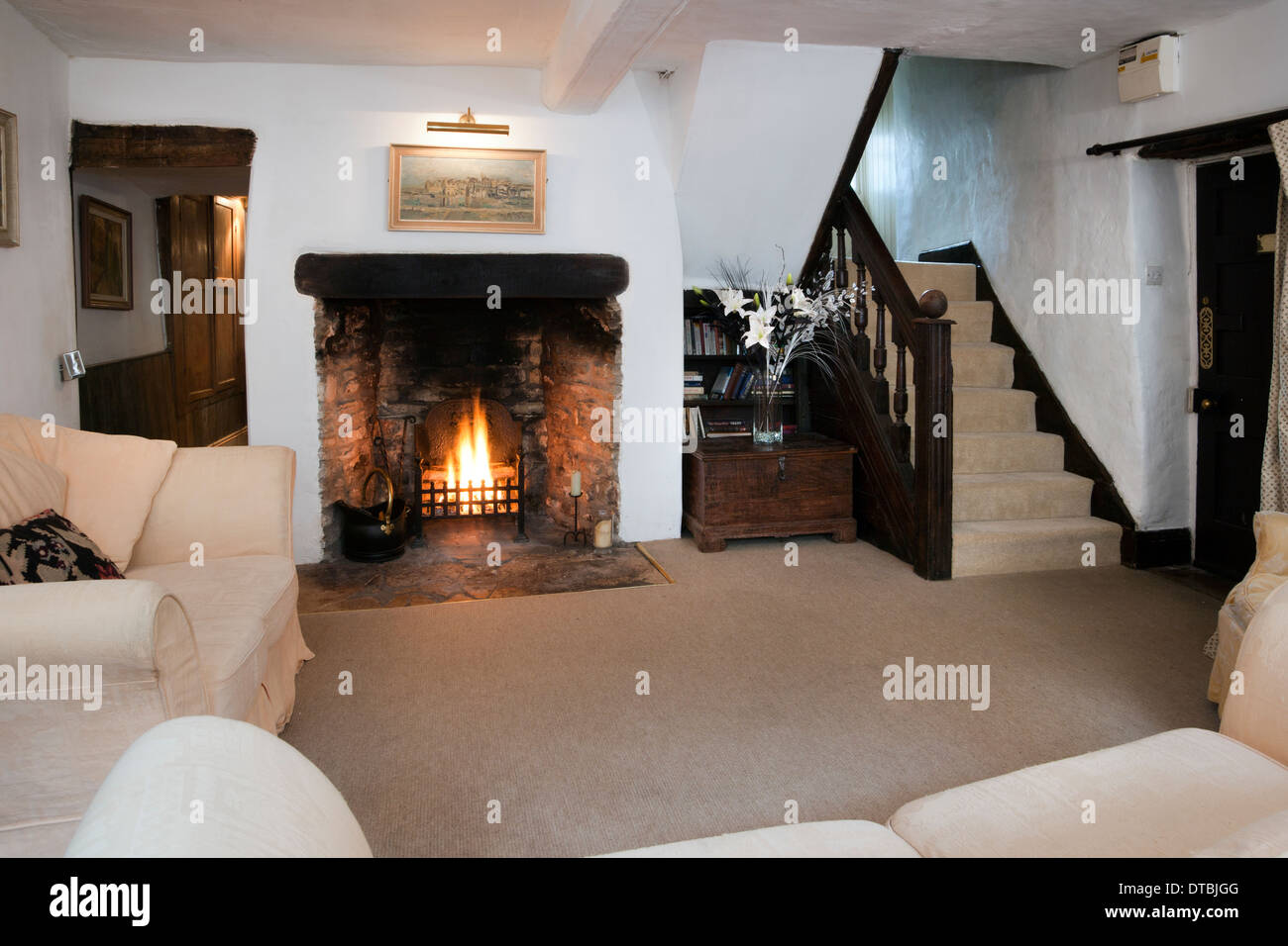 Traditional cottage sitting room with an open fireplace. Stock Photo