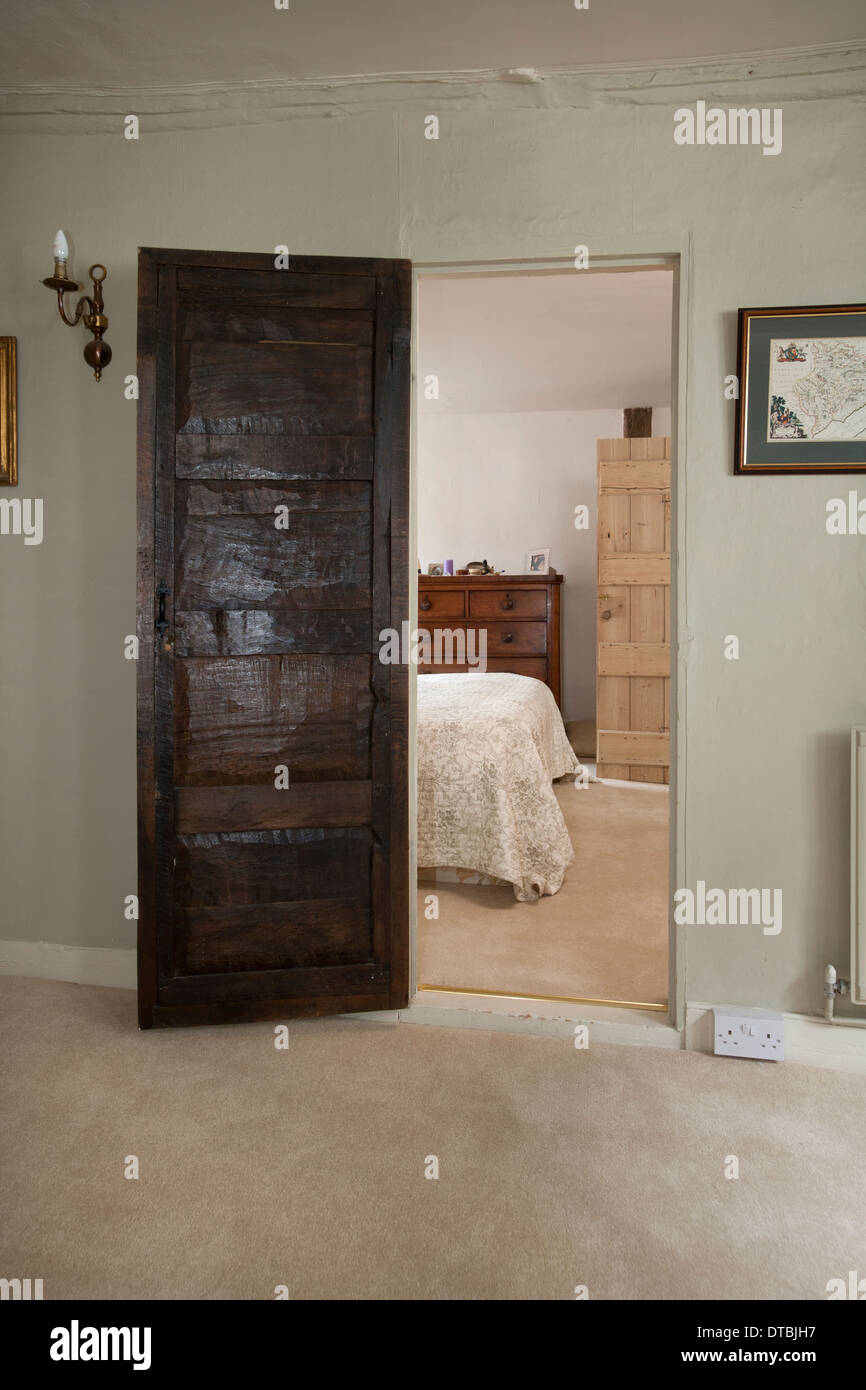 Period house old wood panel door opening onto a bedroom. Stock Photo