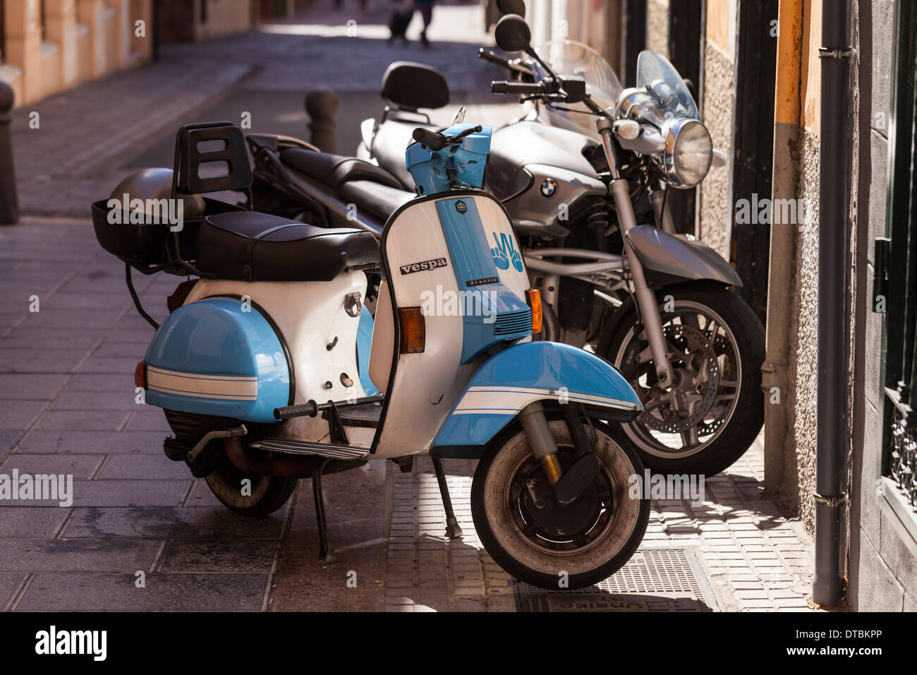 Vespa scooter parked alongside a BMW motorcycle in a side street in Santa ruz, Tenerife, Canary Islands, Spain. Stock Photo