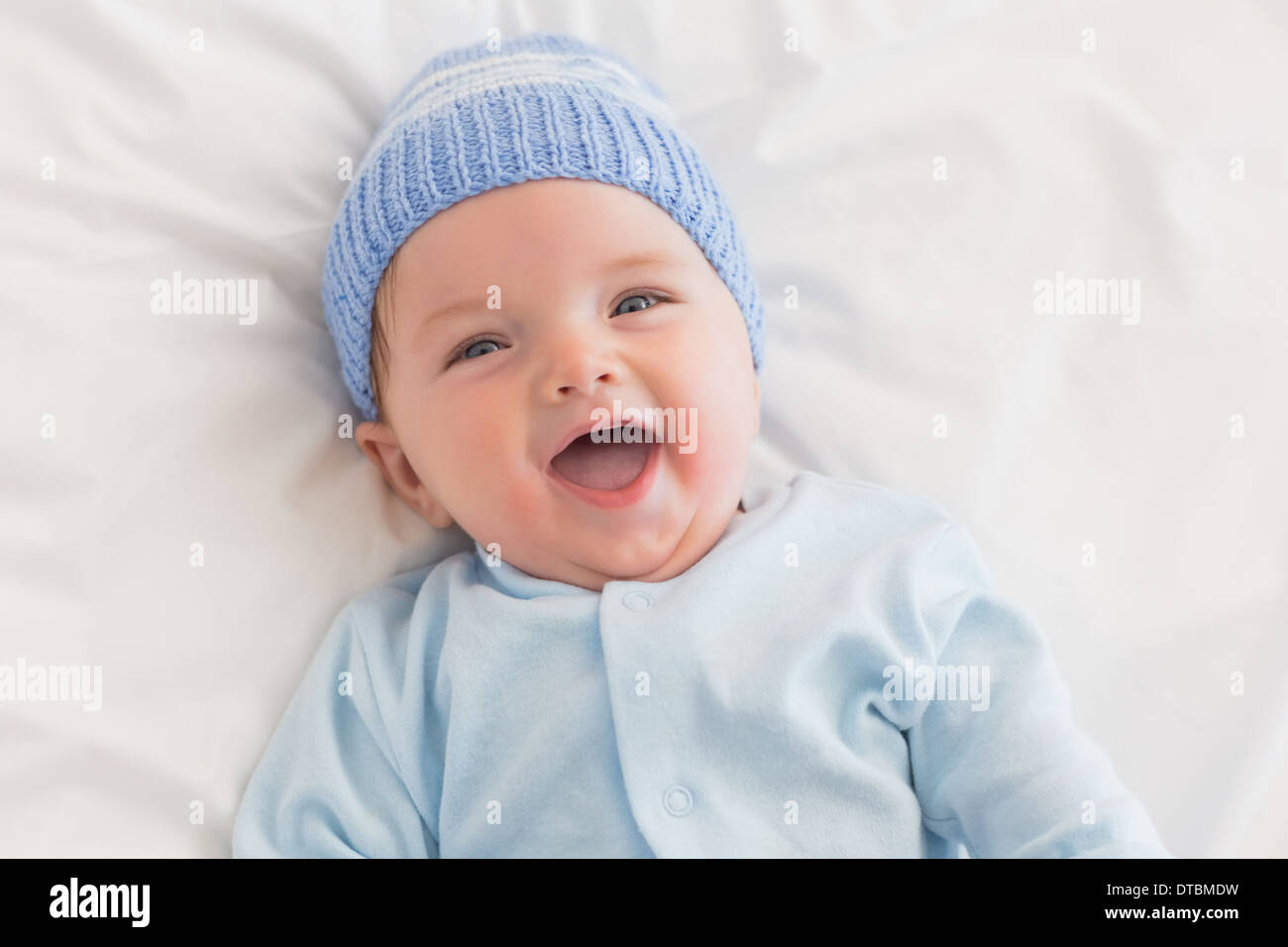 Portrait of cheerful baby in bed Stock Photo