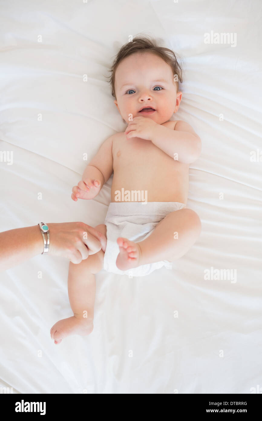 Portrait of cute baby lying in bed Stock Photo