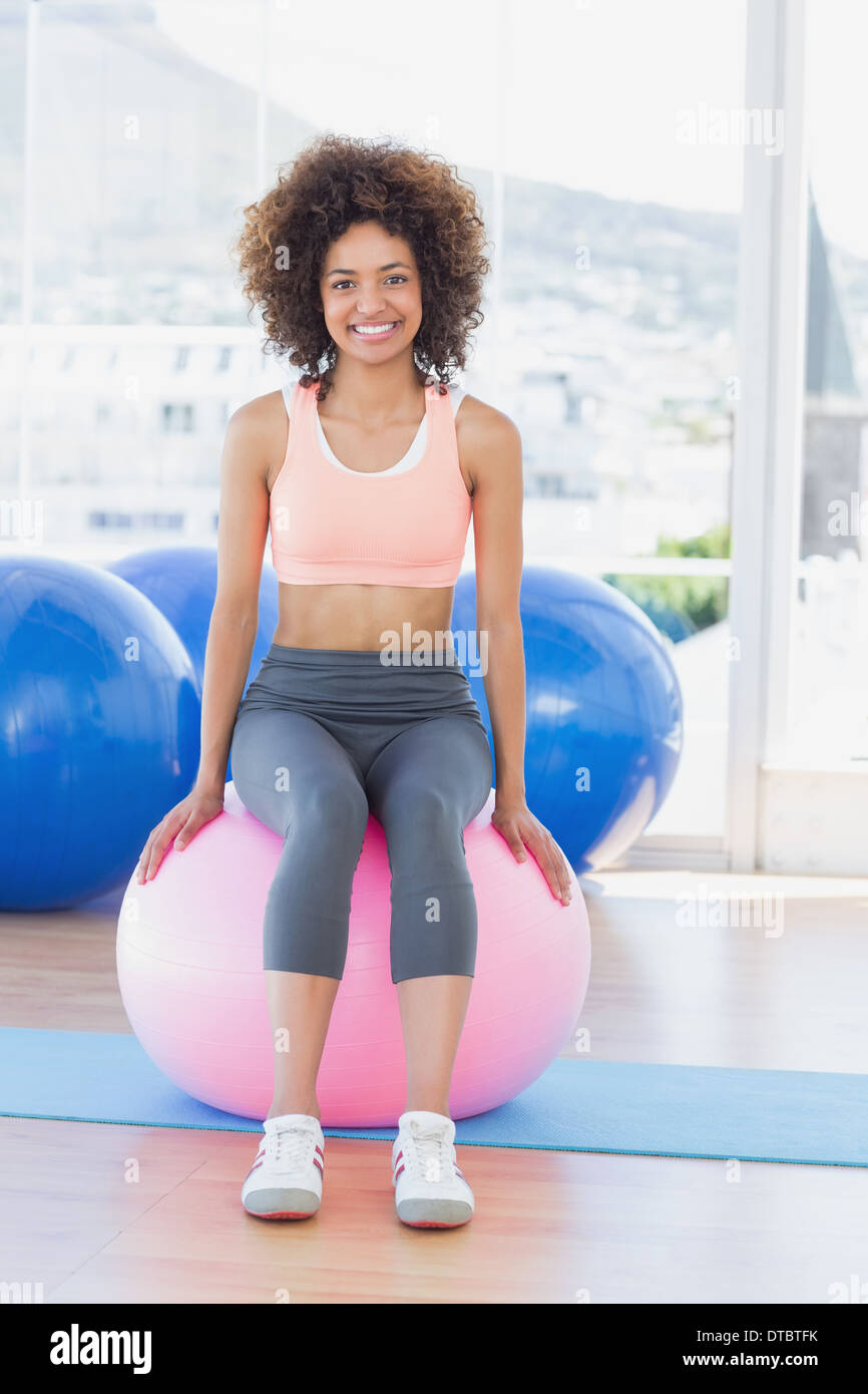 Portrait of a fit woman sitting on fitness ball at gym Stock Photo - Alamy