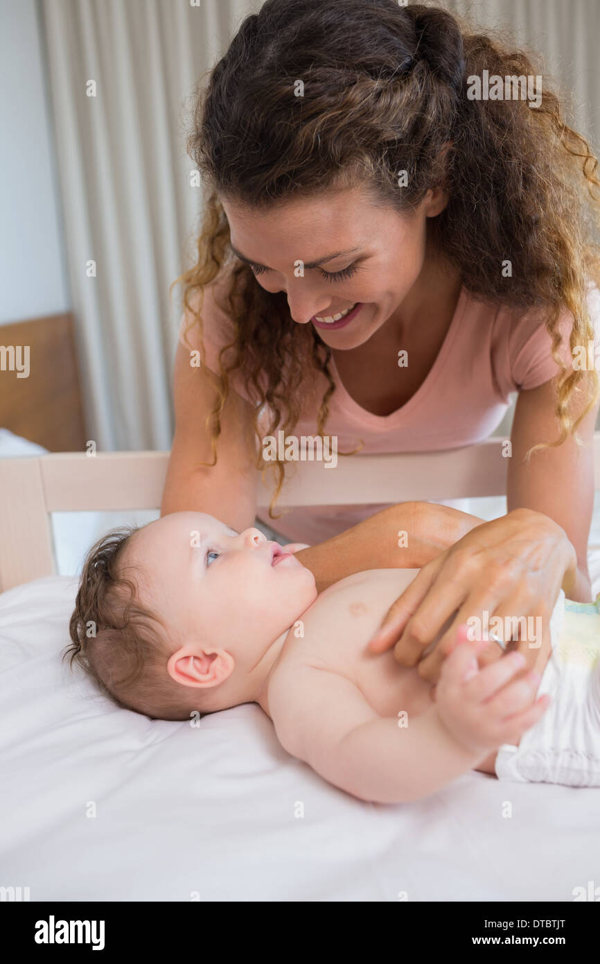 Mother looking at baby lying in crib Stock Photo