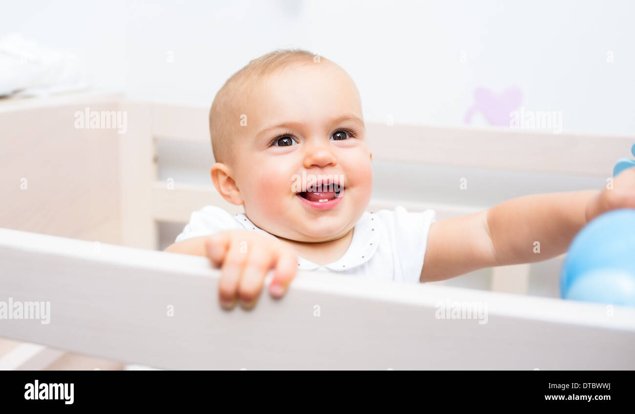 Closeup of a cheerful cute baby in the crib Stock Photo