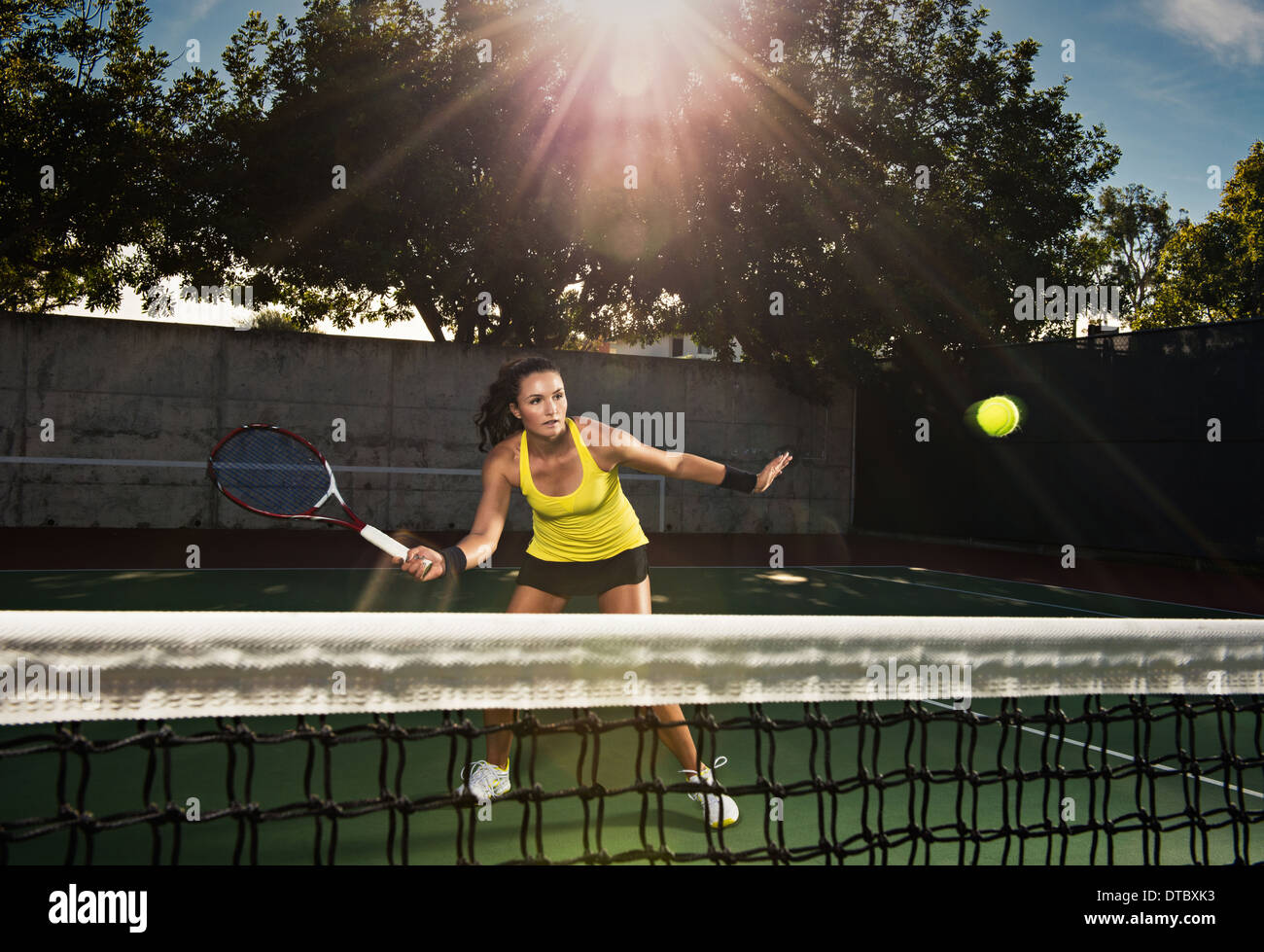 Female tennis player hitting ball over net Stock Photo Alamy