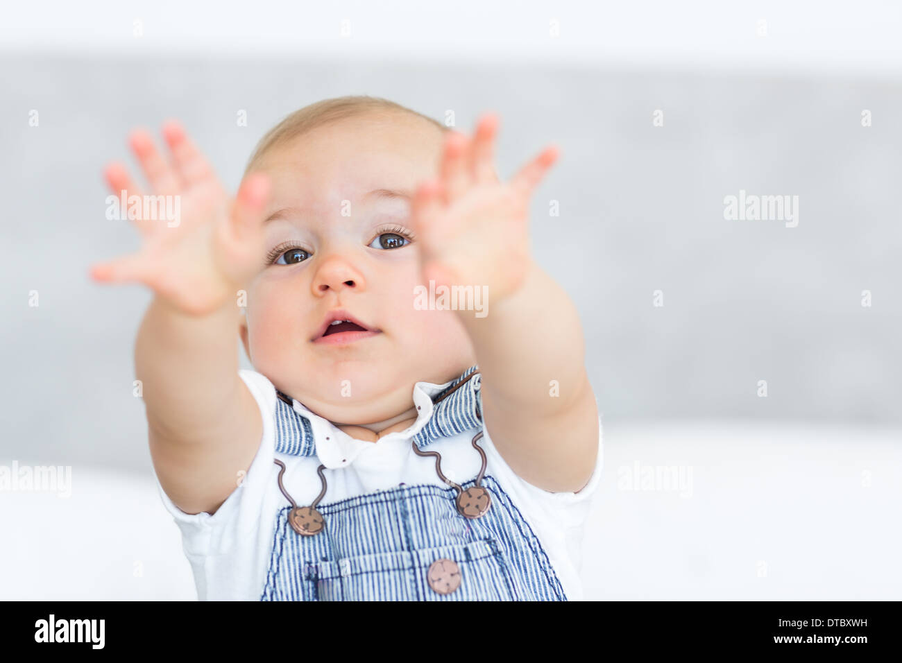Closeup portrait of a cute baby holding out his hands Stock Photo