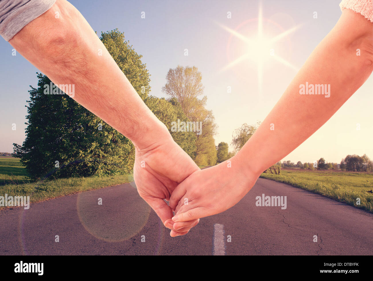 Happy couple holding hands looking in the sunset Stock Photo - Alamy