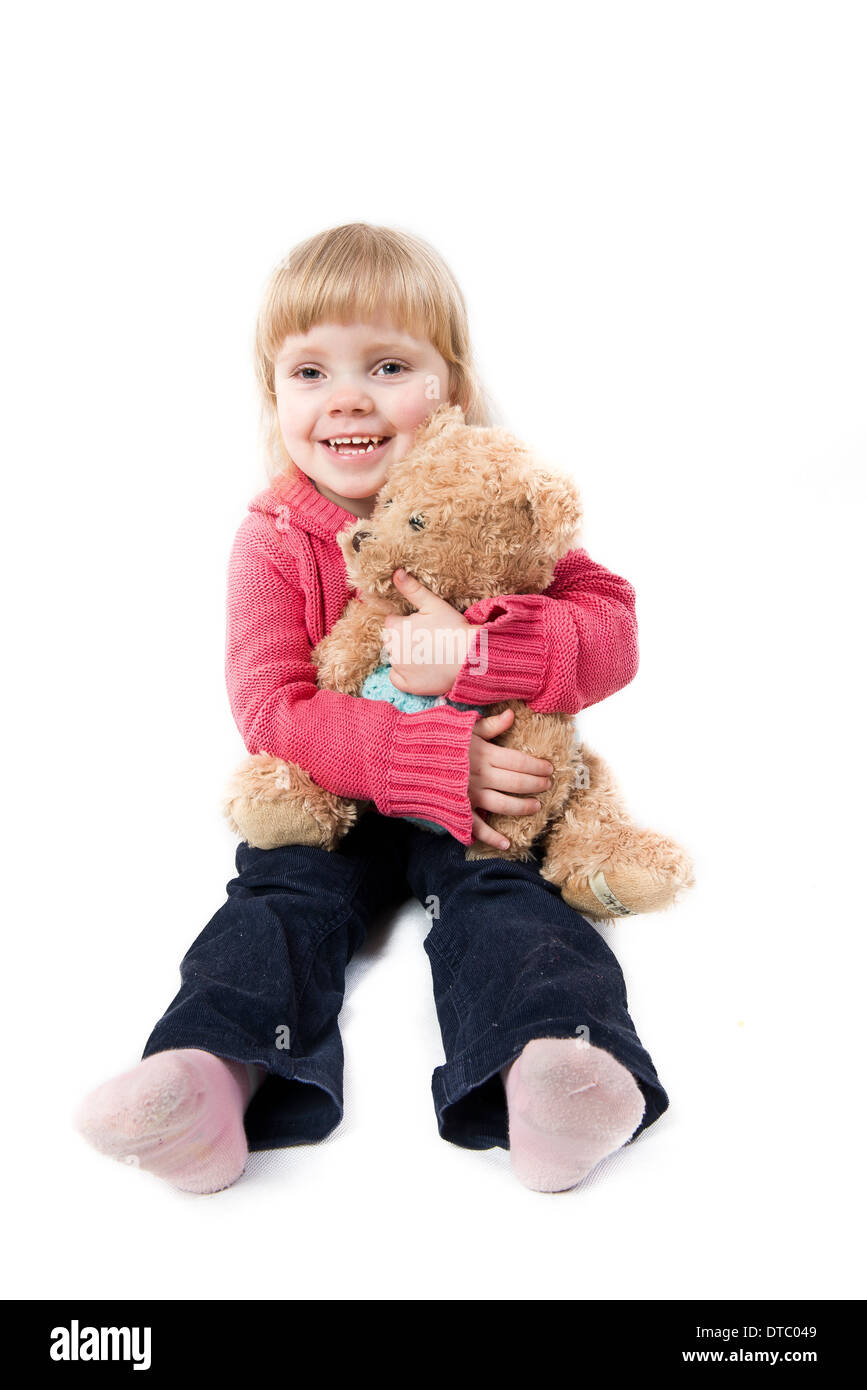little girl sits with a teddy bear on white background Stock Photo - Alamy