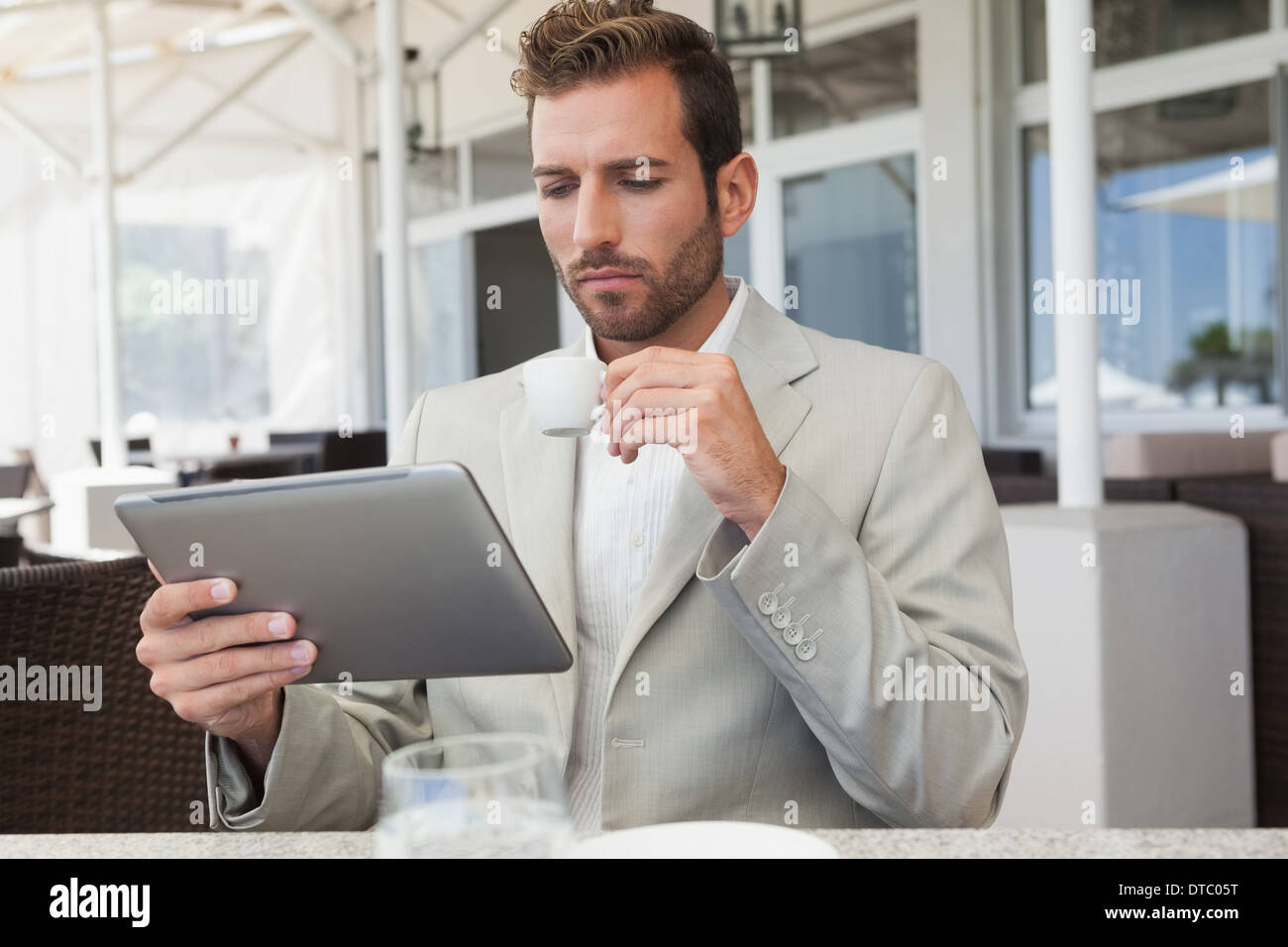Handsome young businessman working on tablet drinking espresso Stock Photo