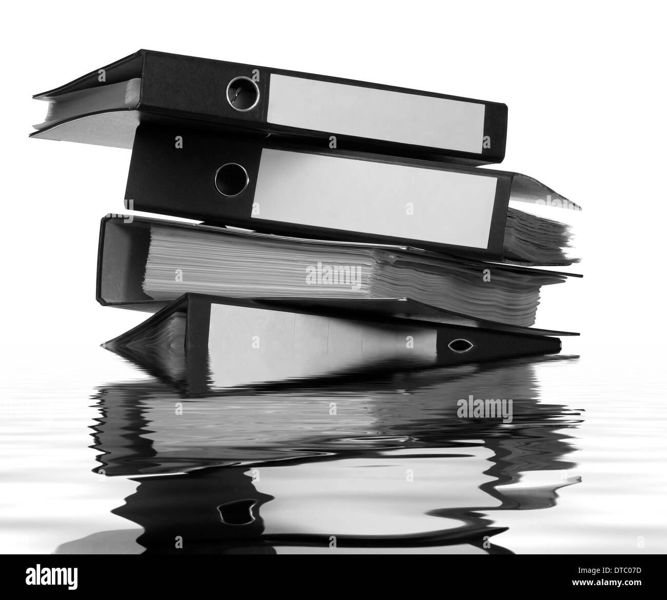 stack of partly sunken folders on reflective water surface Stock Photo