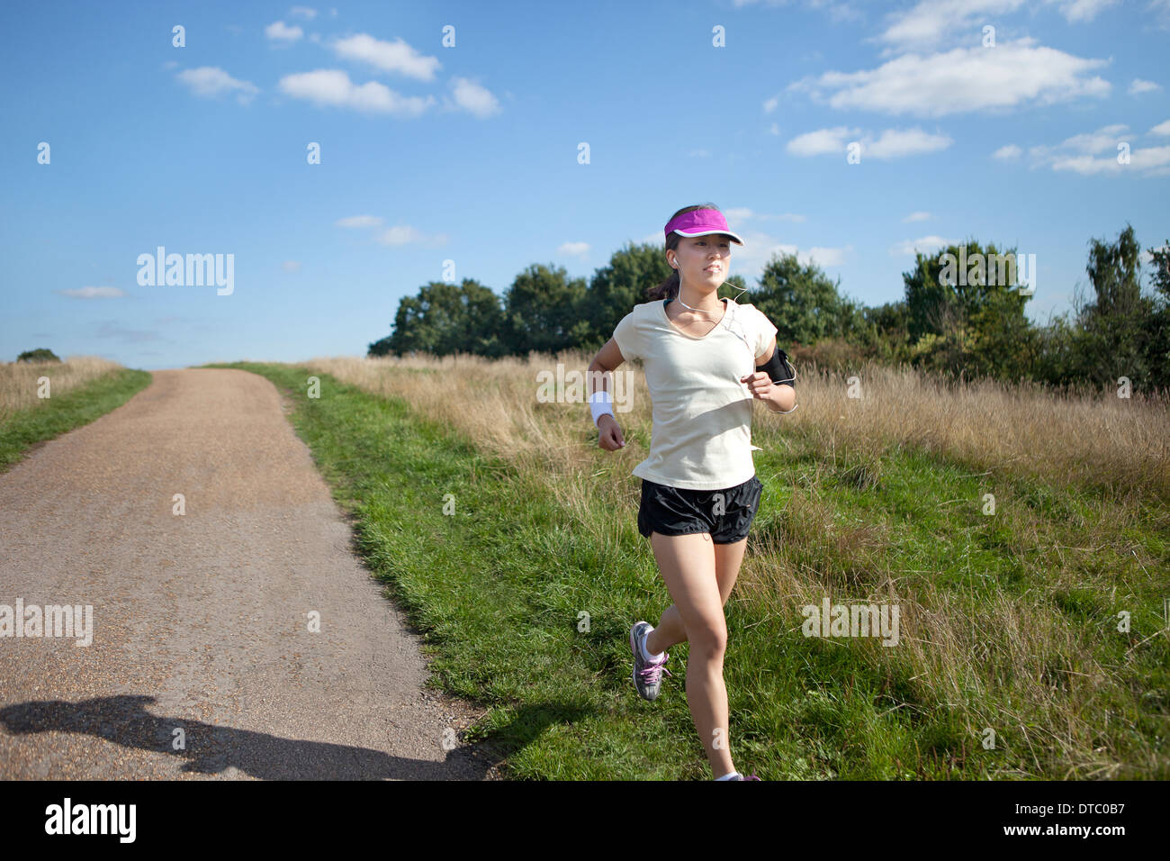Young female runner running alongside dirt track Stock Photo