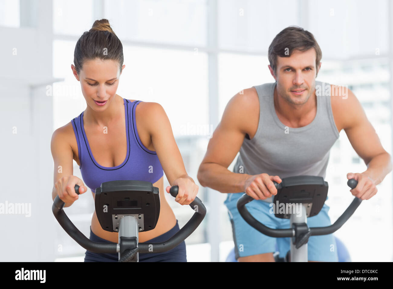 Smiling young couple working out at spinning class Stock Photo - Alamy
