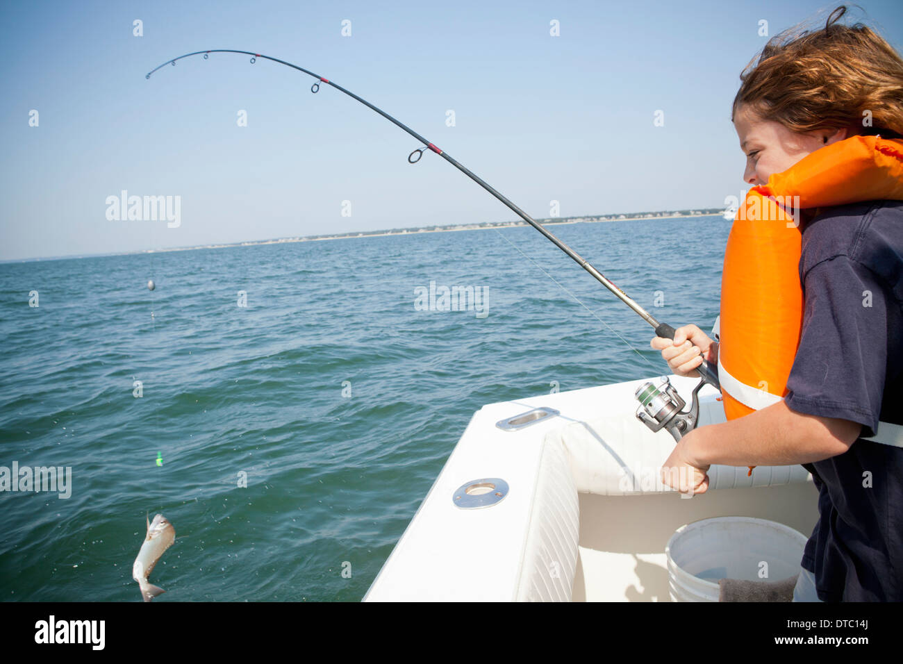 Boy catching fish from boat, Falmouth, Massachusetts, USA Stock Photo
