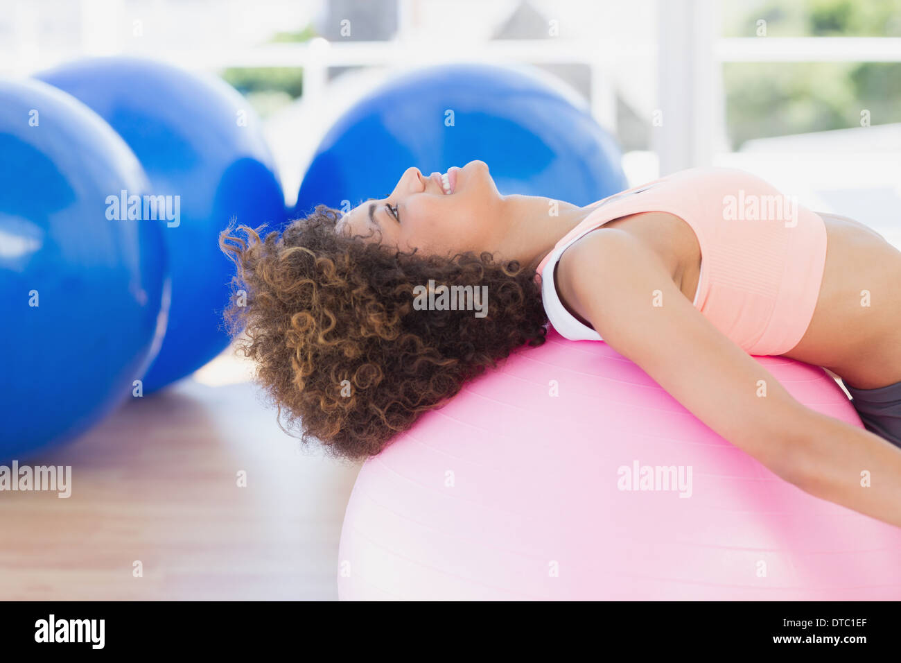 Side view of a fit young woman exercising on fitness ball Stock Photo ...