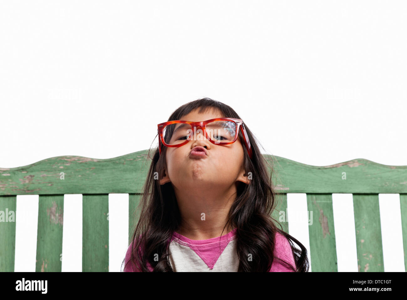 Studio portrait of young girl with puckered lips Stock Photo