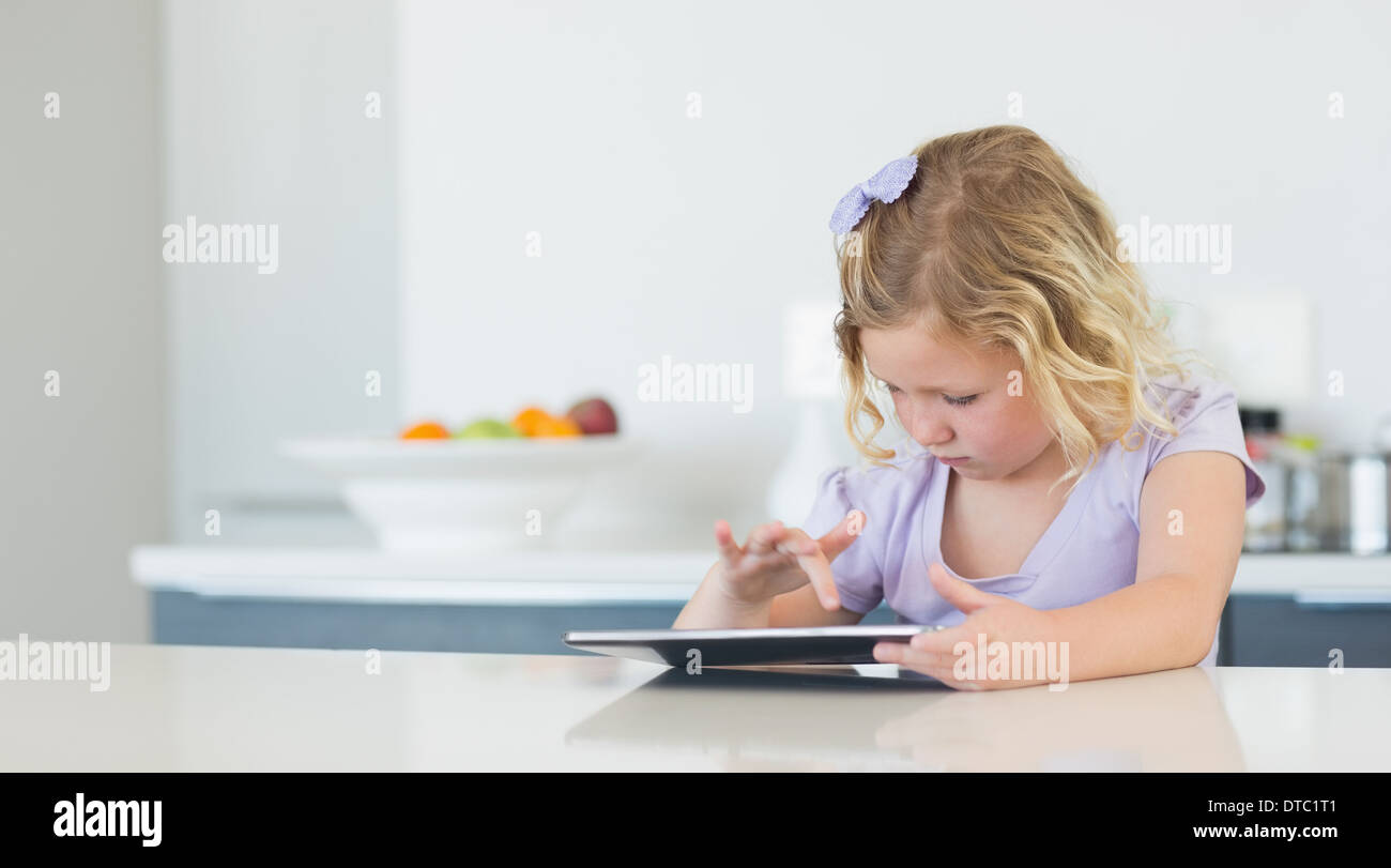 Girl touching digital tablet at table Stock Photo